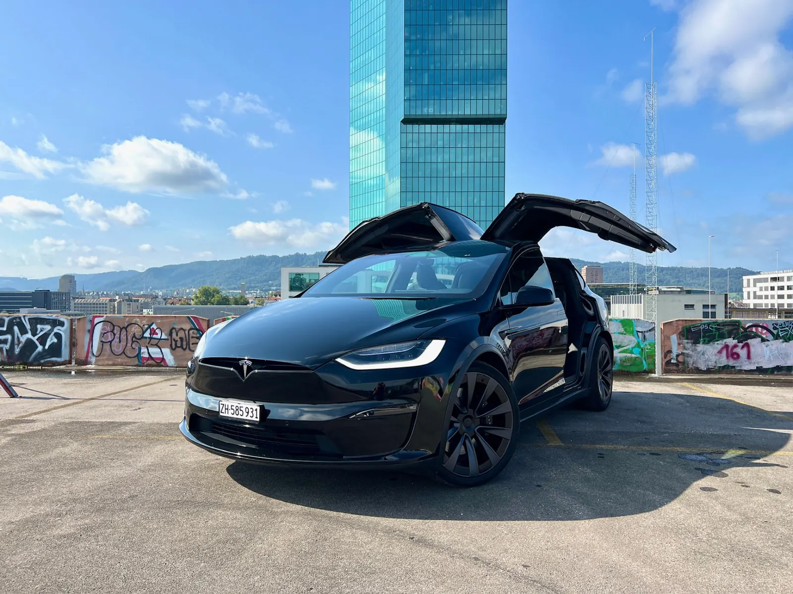 Schwarzer Tesla Model X Plaid mit offenen Flügeltüren vor dem Prime Tower in Zürich